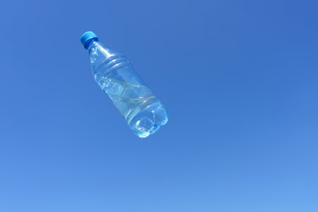 Plastic water bottle moving through the air against a blue sky