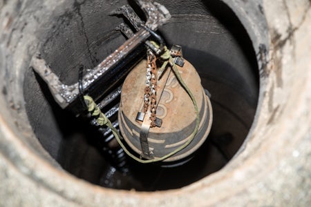 Metal device lowered into manhole