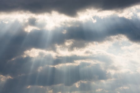 Sunrays streaming through dark clouds.