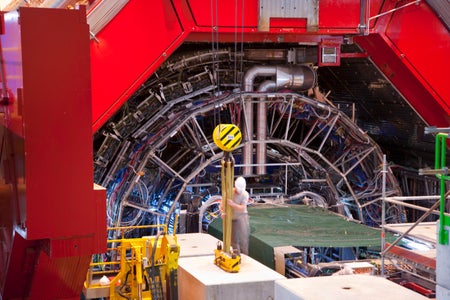 A man stands in front of an enormous device festooned with electronics.