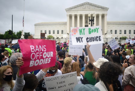 Women protest holding signs