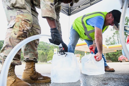 Army National Guard assisting a resident with potable water.