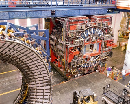 A large, cube-shaped collision detector is rolled at Fermilab.