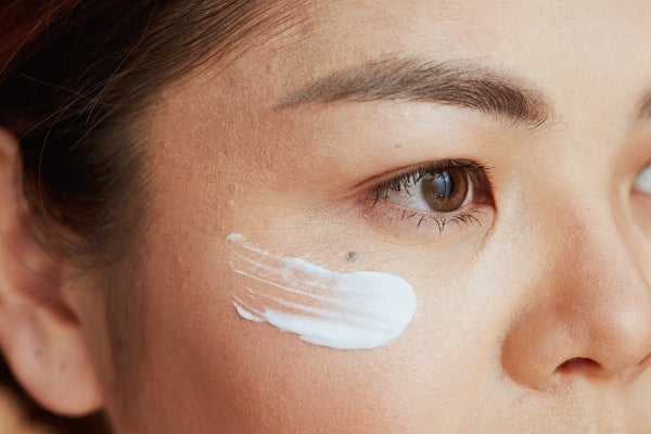 Closeup of Asian woman with eye cream on face