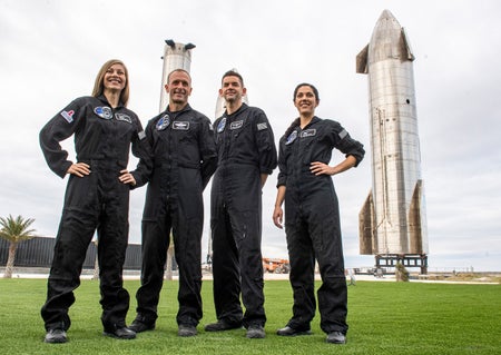 The crew of Polaris Dawn, (left to right) Anna Menon, Scott Poteet, Jared Isaacman and Sarah Gillis, pose in front of rocket stages at SpaceX’s Starbase Complex in Boca Chica, Texas. A