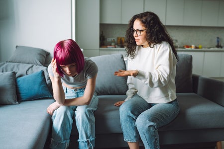 Teenage girl getting a scolding from her mother in the living room.