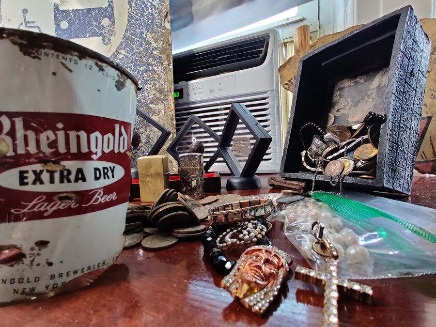 Various objects found by magnet fishers including jewelry, lighters, and a beer can